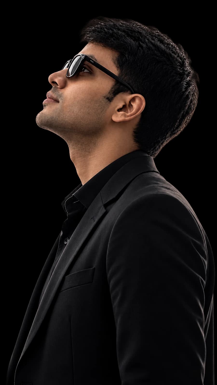 Prashant Yadav in a black suit, looking upward